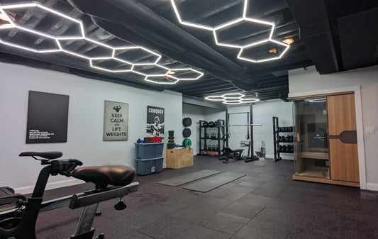 Wide view of a basement home gym in Plymouth, MI with strength and cardio areas