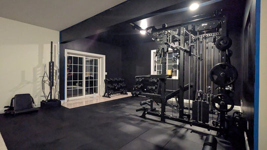 Finished walkout basement home gym in Kenockee, Michigan with an all in one rack, cable stacks, adjustable bench, and black rubber flooring