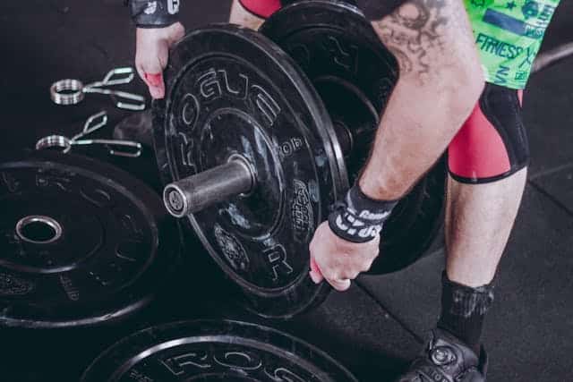 Tattooed weightlifter loading barbell